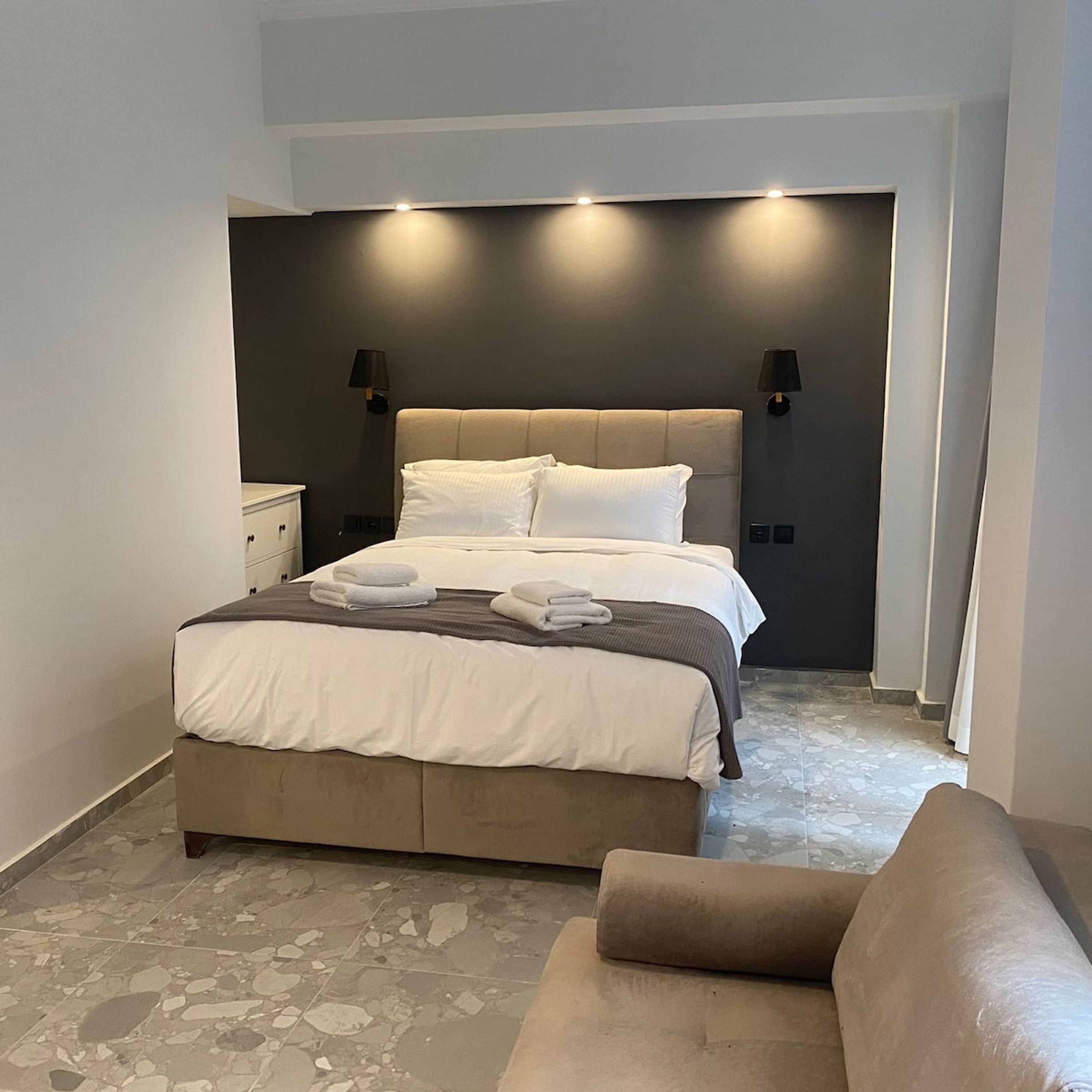 Una camera da letto moderna con un letto grande, due lampade da comodino e un comodino.