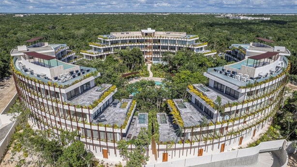A circular hotel with multiple floors, outdoor pools, and lush greenery surrounding the property. - Marvelous studio with pool views, fast Wi-Fi and A/C (Tulum)