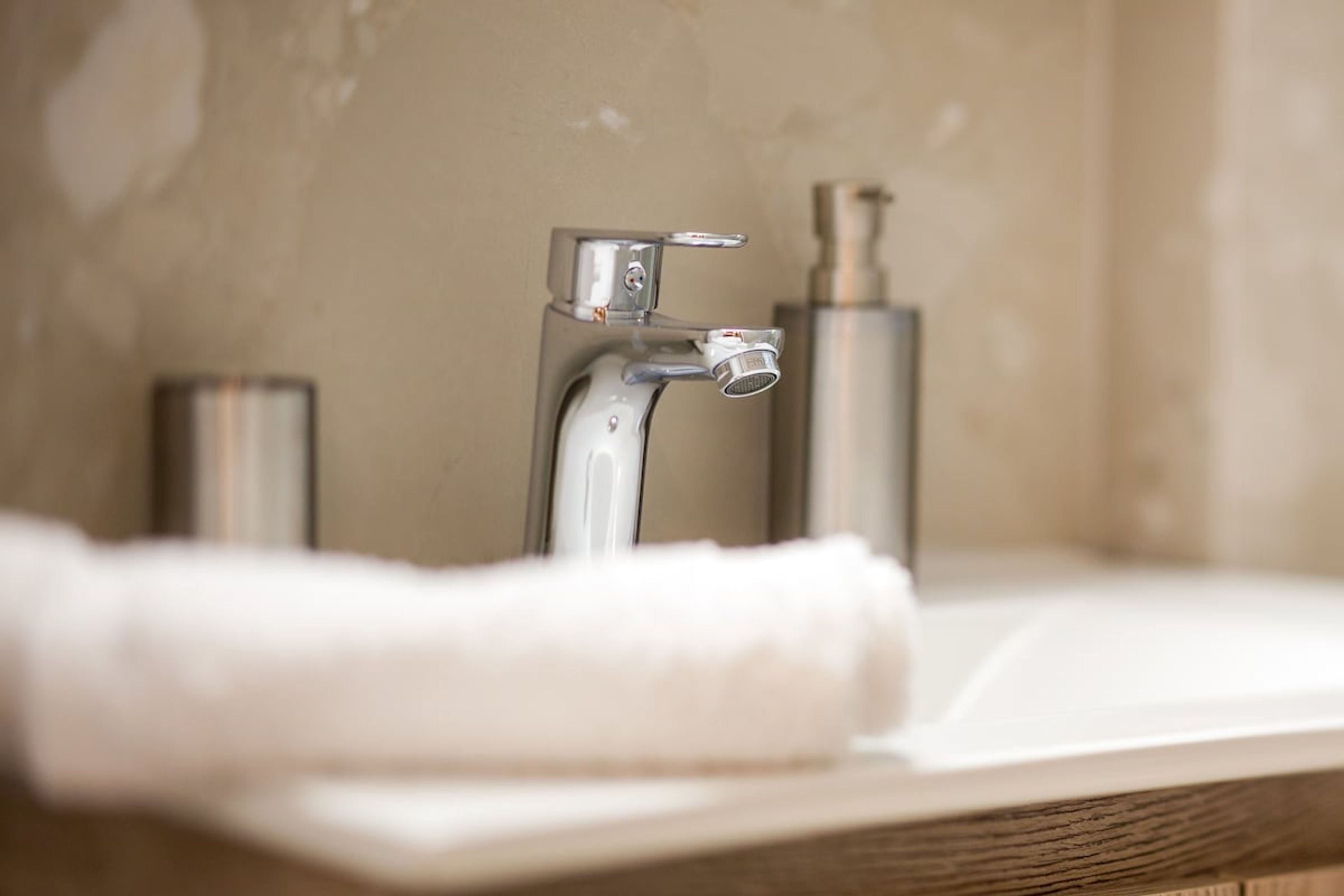 Un lavabo de salle de bain doté d’un robinet moderne et d’un distributeur de savon.