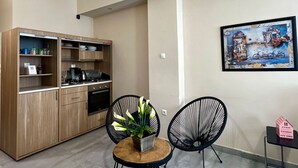 Una cocina moderna con armarios de madera, una mesa de comedor con sillas e iluminación colgante.