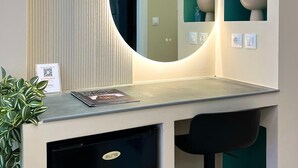 Ein modernes Badezimmer mit einem runden Spiegel, einem Waschbecken und einem kleinen Schrank.
