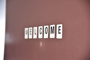 A close-up of a wall with the word "WELCOME" spelled out in individual letter tiles. - Athens Tiny rooftop by Super Host Hub (Μενεμένη)