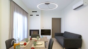 Ett modernt vardagsrum med en matplats, en soffa och en tv-apparat med platt skärm.