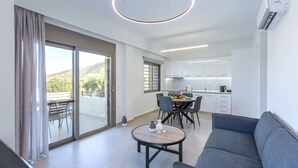Un salon moderne comprenant un canapé, une table à manger avec des chaises et un coin cuisine avec des placards et un plan de travail.