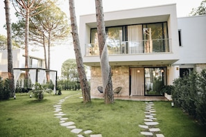 A modern two-story house with a stone facade, a covered outdoor seating area, and a stone pathway leading to the entrance. - Parrot's Home in Plazhi San Pietro (Plazhi San Pietro)