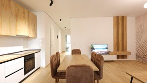 Een moderne keuken met houten kastjes, een eettafel en stoelen.