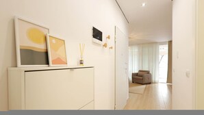 Een moderne woonkamer met een bank, een kast met kunstwerken en een deur naar een andere kamer.