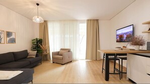 Een moderne woonkamer met een bank, een stoel, een eettafel en een televisie.