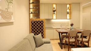 Una cocina moderna con armarios de madera, una mesa de comedor con sillas y un sofá.
