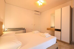 Ein Hotelzimmer mit Bett, Nachttisch, Spiegel und Klimaanlage.