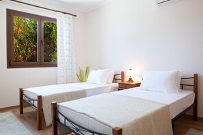 A room with two single beds, a window with a view of greenery, a bedside table with a lamp, and a white curtain. - Buena Vista Villa - Amazing sea view (Ligia)