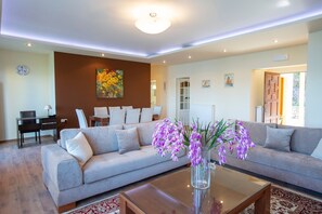 Ein modernes Wohnzimmer mit einer Couch, einem Couchtisch und einer Blumenvase.