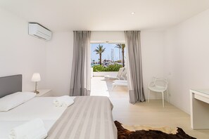 A hotel room with a bed, a desk, a chair, and a view of a marina. - Vista dos Seus Sonhos! | T2 HsRentals Vilamarina (Vilamoura)