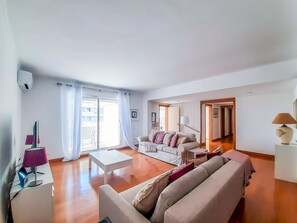 Ein geräumiges Wohnzimmer mit einer Couch, einem Couchtisch und einer Lampe.