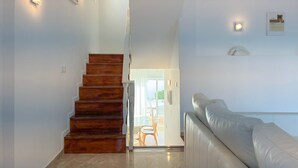 A staircase leading to a balcony, a white sofa, and a framed picture on the wall. - Vila Shradhala | V4 HsR Marina Vilamoura (Vilamoura)