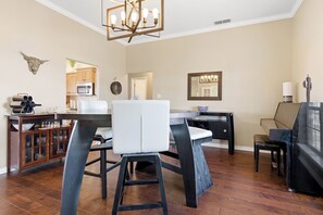 A modern kitchen with a dining area, wooden flooring, and a chandelier. - New! Spacious 3BR Getaway, Easy Access to Abilene, Sleeps 6 (Tuscola)