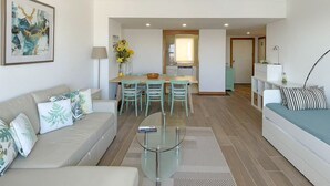 Una sala moderna con un sofá, una mesa de centro y un comedor con sillas y una mesa.