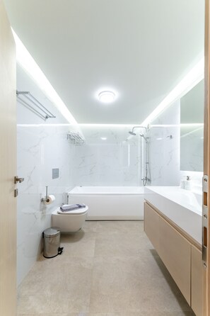 Un bagno moderno con vasca, servizi igienici e doccia.