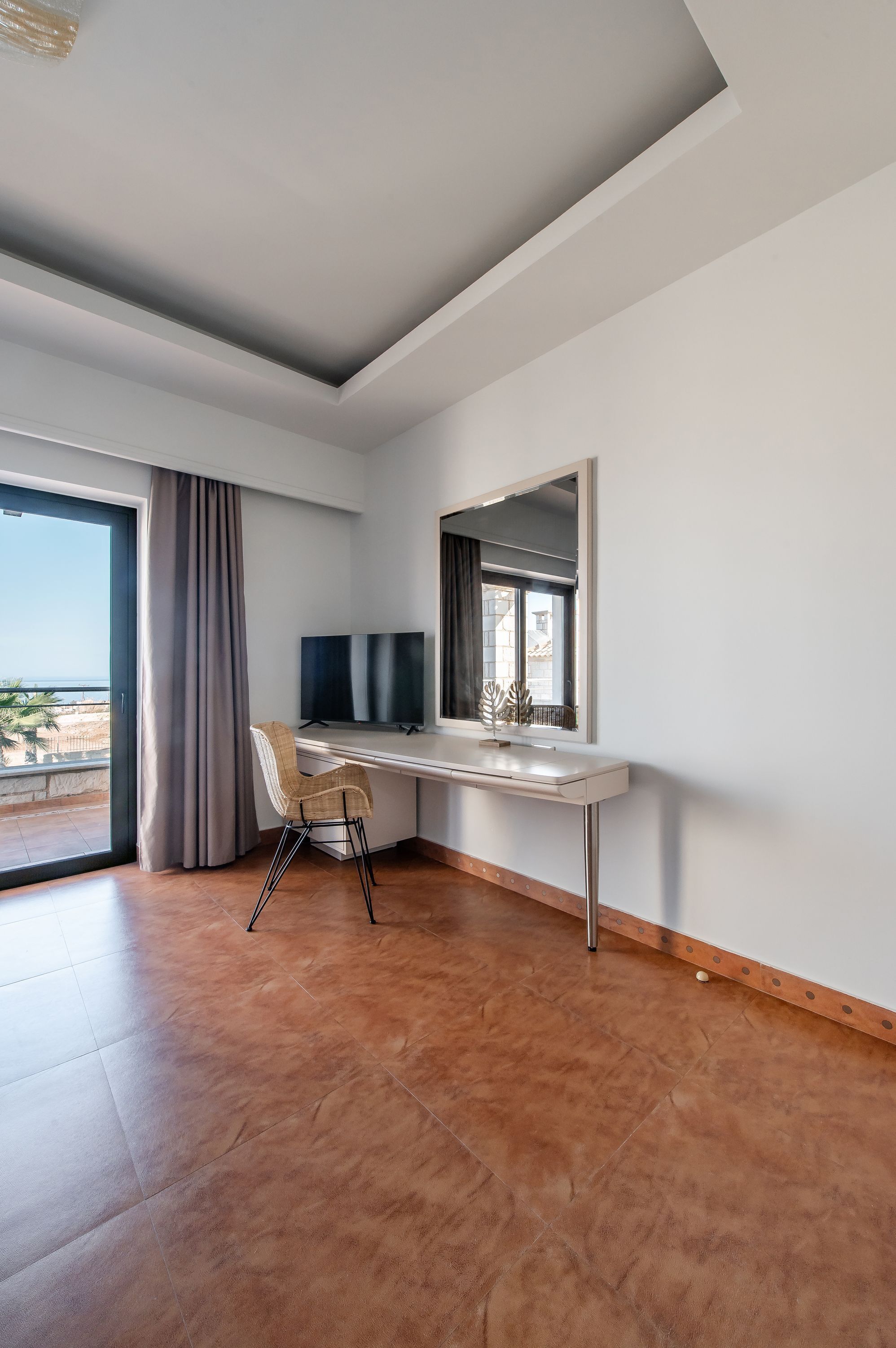 A modern room with a desk, chair, and large window.