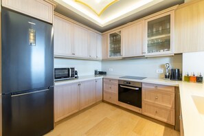 A modern kitchen with light wood cabinets, a stainless steel refrigerator, a microwave, and a dishwasher. - Bliss Villa 3 with private swimming pool (Anissaras)