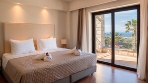 Ein Hotelzimmer mit einem großen Bett, einem Nachttisch, einer Lampe und einem Balkon mit Blick auf Palmen und das Meer.