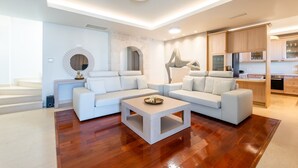 Ein modernes Wohnzimmer mit einer Eckcouch, einem Couchtisch und einer Küche im Hintergrund.