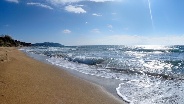 Una playa con arena y olas.