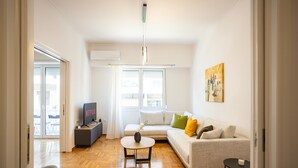 Un salon moderne avec un canapé, une table basse et un téléviseur.