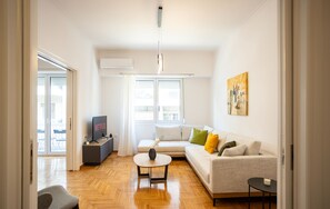 A modern living room with a sofa, coffee table, and TV. - Elegant 3-Bedroom Retreat in the Heart of Kolonaki (Athina)