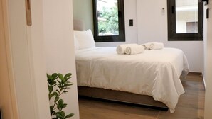 A bedroom with a bed, a window, and a plant. - No 2 - Theo Apartment two bedrooms ground floor (Athina)