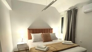 Een moderne slaapkamer met een groot bed, een nachtkastje en een plafondlamp.
