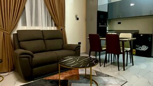 A living room with a sofa, a coffee table, and a ceiling fan. - Two Bedroom Apartment, BH Apartments Dansoman Heights (Dansoman)