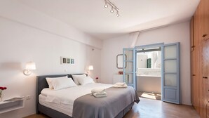 Une chambre moderne avec un grand lit, des lampes de chevet, une armoire et un miroir.