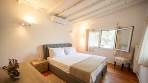 Un dormitorio con cama, mesita de noche y cortinas en la ventana.