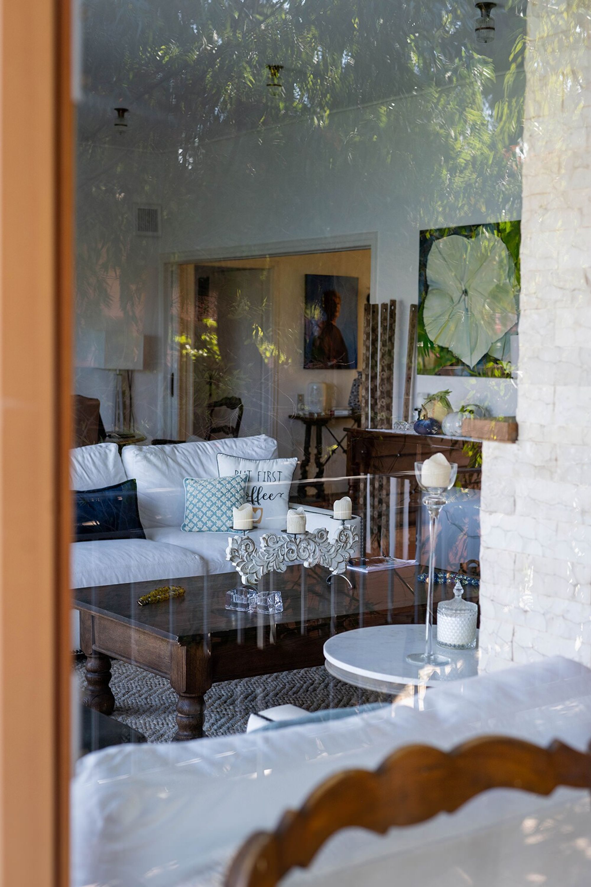 A cozy living room with a white sofa, a round coffee table, and a glass display case.