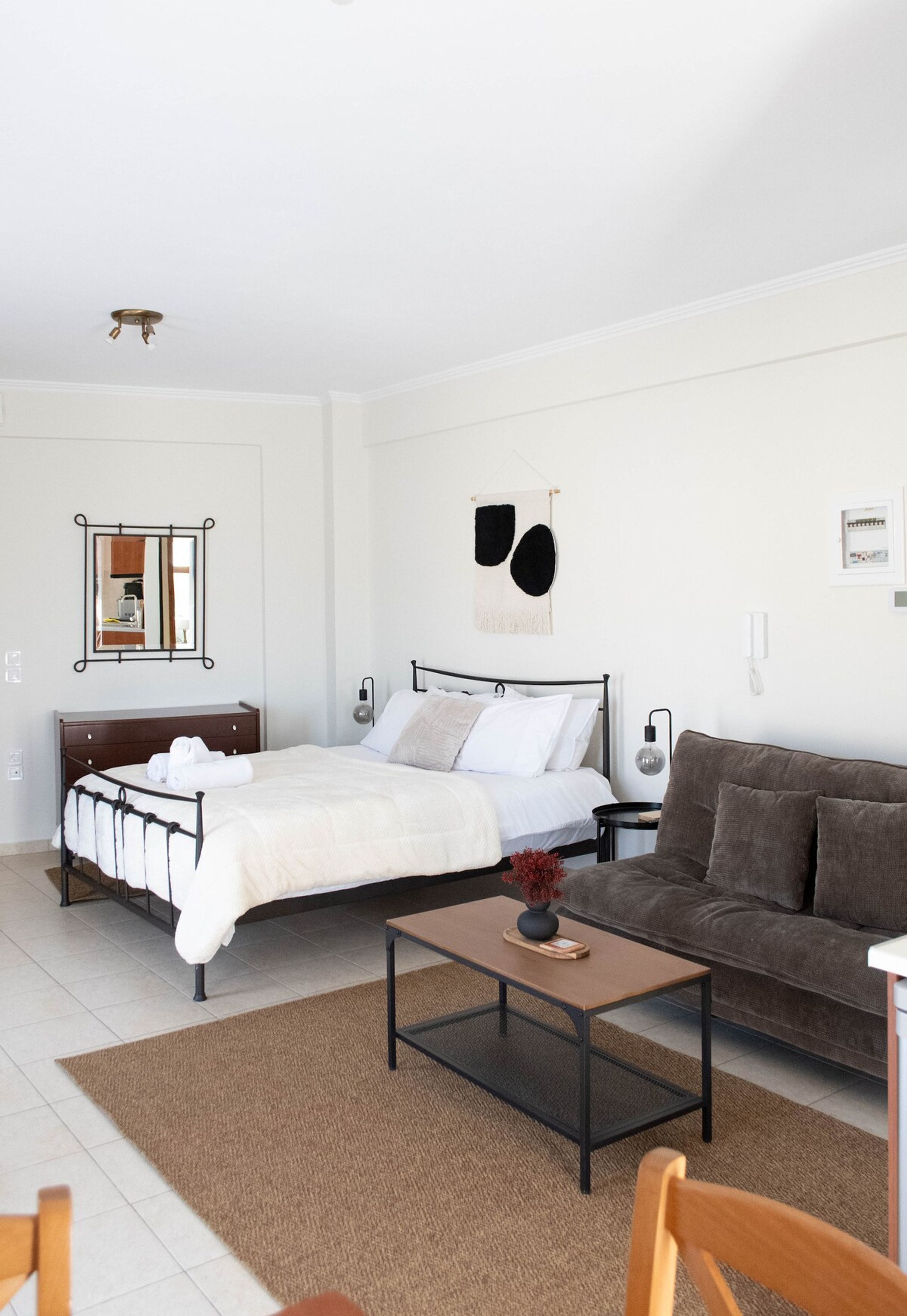 Une chambre à coucher avec un lit, une table de chevet et un canapé marron.