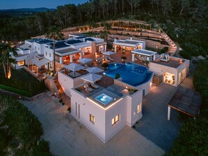 Ein modernes Resort mit mehreren Gebäuden, einem Schwimmbad und Außenbereichen zum Sitzen.