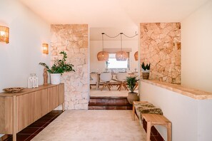 Ein modernes Interieur mit Steinwand, hölzernem Bank und Essbereich im Hintergrund.