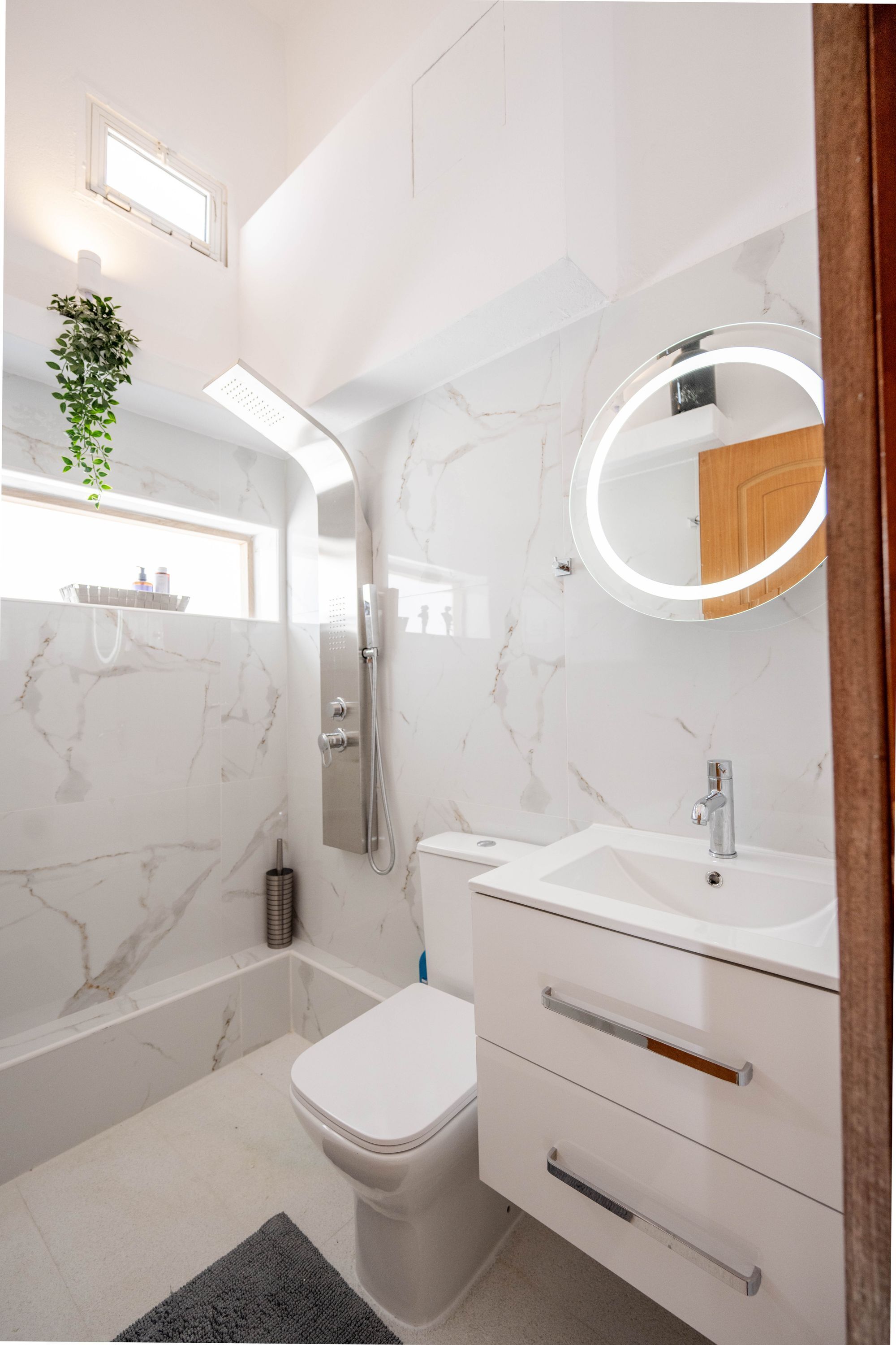 A modern bathroom with a shower, toilet, and vanity.