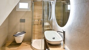 Une salle de bain moderne avec une douche à parois de verre, un lavabo sur pied et un meuble-lavabo en bois.