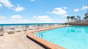A pool area with lounge chairs and a view of the ocean. - King Studio with Partial Water Views, Heated Pool, Beach Access (Daytona Beach)