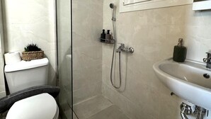 A modern bathroom with a glass-enclosed shower, a toilet, and a sink. - Athenian Stay Chara's 2 Apartment (Neo Psichiko)