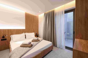 Une chambre d’hôtel moderne avec une tête de lit en bois, un grand lit avec du linge de lit blanc, une table de chevet avec une lampe et une vue sur la ville par une grande fenêtre.