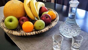 A dining table with a fruit basket, two shot glasses, and a crystal decanter. - La Casa di Teta by superhosthub (Galatas)