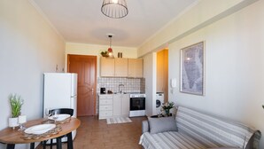 Un espacio habitable compacto con comedor, kitchenette y sofá.
