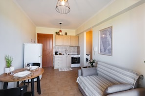 A compact living space with a dining area, kitchenette, and a sofa. - Casa Vardani 1 Modern Central Apartment (Lefkada)