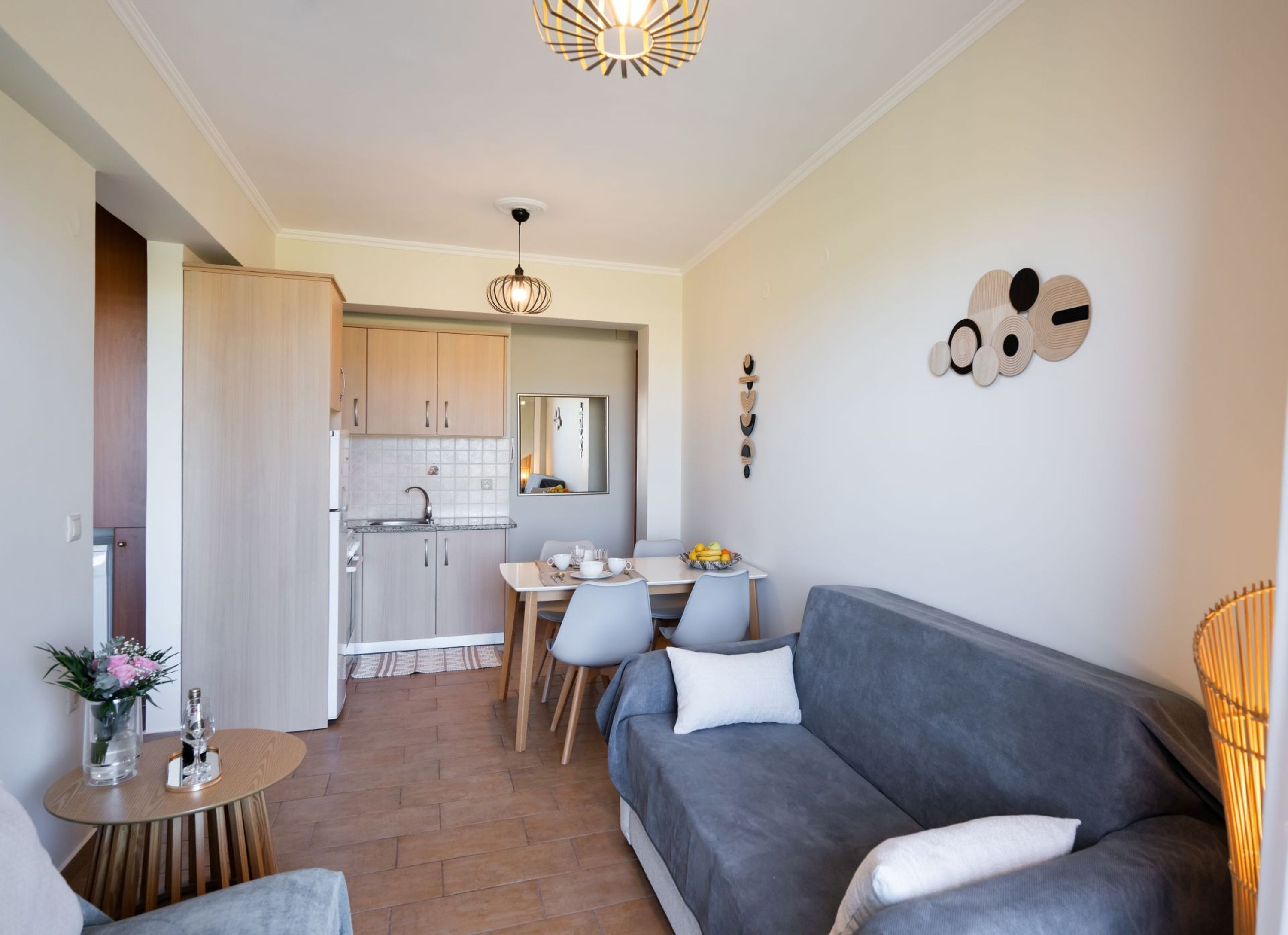 A compact living space with a kitchenette, a dining area, and a seating area with a sofa and chairs.