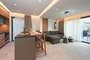Eine moderne Wohnung mit Küche, Essbereich und Wohnzimmer. Sie verfügt über ein großes Fenster, einen Esstisch mit Stühlen, ein Sofa und zwei kleine Beistelltische.