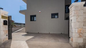 Un edificio moderno con fachada de piedra, cielo despejado y un cartel que dice "ARTEMIS VILLAS".