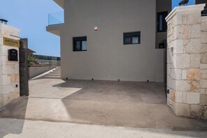 Ein modernes Gebäude mit einer Stein-Fassade, blauem Himmel und einem Schild mit der Aufschrift "ARTEMIS VILLAS".
